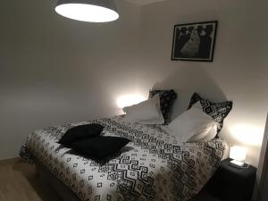 a bedroom with a bed with black and white pillows at Villa le Tresquel in Mostuéjouls +19 photos