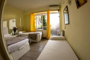 プラヤ・デ・パルマにあるHostal Alceのベッド2台と窓のある病室です。