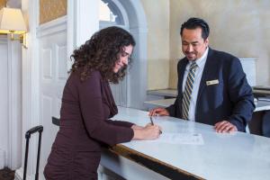 een man en een vrouw ondertekenen een document aan een tafel bij Hotel Amari in San Francisco