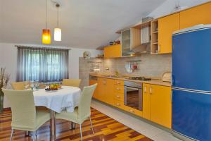 kuchnia ze stołem i żółtymi szafkami w obiekcie Villa Giardina Apartments w mieście Vinkuran