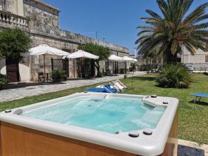 una vasca idromassaggio in un cortile accanto a un edificio di Villa Papaleo B&B a Bagnolo del Salento