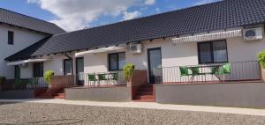 a house with green chairs on the balcony at Pensiunea Gloria in Baile Felix