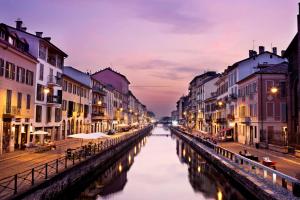 un canal en medio de una ciudad por la noche en Il Naviglio dietro l'angolo, en Milán