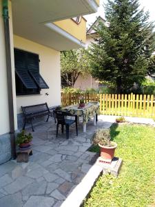 un patio con tavolo e panche in un cortile di CasaBruna ad Albiano
