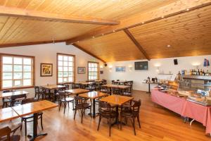 a restaurant with wooden ceilings and tables and chairs at Guesthouse Fludir in Fludir
