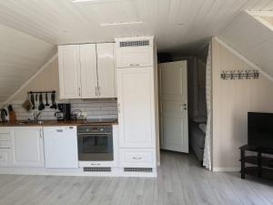 cocina con armarios blancos y fogones en Loftet, Nyksund en Nyksund