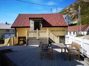 a house with a deck with a table and two chairs at Loftet, Nyksund in Nyksund