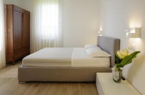 1 dormitorio con 1 cama y un jarrón de flores en Casa Selene Rocchi, en Savignano sul Panaro