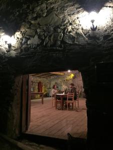 Due persone sedute a un tavolo in una grotta di Guest House Keti Margiani Mestia a Mestia