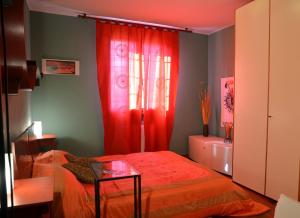 una camera con tenda rossa e letto di La Casetta a Campogalliano
