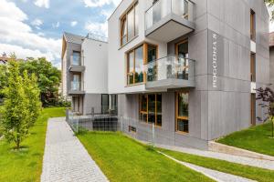 an exterior view of a building with a green yard at Pogodna Apartments in Sopot