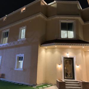 a large house with a front door at night at Al Taif Villas in Ash Shuwaybiţ