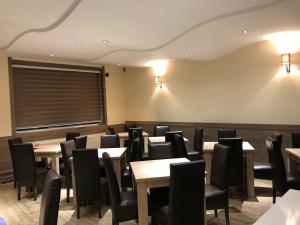 a dining room with tables and chairs and lights at Vila Zlatarka in Nova Varoš