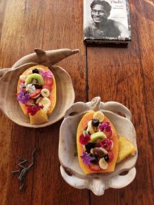 two tacos in wooden plates on a wooden table with a photo at Ma'ukele Lodge in Pahoa