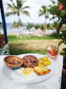 a plate of food on a table with a plate of food at Nimbu Beachhouse in Transito