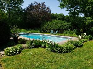 ein Schwimmbad in der Mitte eines Gartens in der Unterkunft Auberge du Vignoble Bromont in Bromont