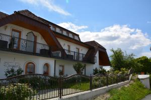 a large white house with a black fence at Pension Restaurant Rosenberg in Jennersdorf