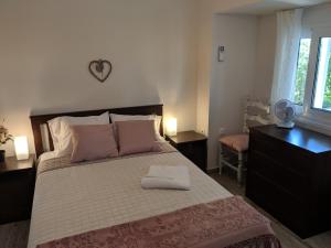 a bedroom with a large bed with pink pillows at Herodicus villa in Nea Skioni