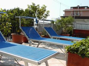a row of blue chairs sitting on a roof at Hotel Metron in Cesenatico