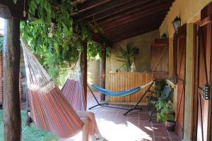 a woman sitting in a hammock on a porch at Casa RioTempo + Jangada in Tomar