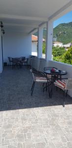 a patio with chairs and a table and a table and benches at Apartment Djordje Budva-Jaz in Kukaljevina