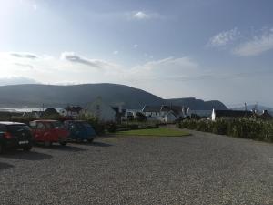 a parking lot with cars parked in front of a house at Roskeel House in Achill