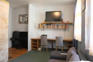 sala de estar con sofá y escritorio con TV en Apartment Rumbas - 6, en Kuldīga