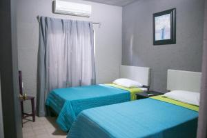 ein Zimmer mit zwei Betten in Blau und Gelb in der Unterkunft COLONIAL SUITES # DOS in Ciudad Valles + 31 Fotos