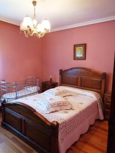 een slaapkamer met een groot houten bed en een kroonluchter bij Apartamento Casa Geli # 2 in Onís