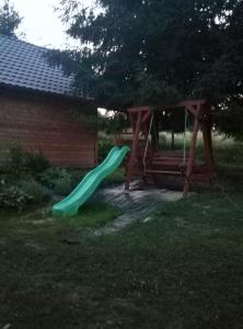 a playground with a green slide in a yard at Chrząszczewo Widokowe wzgórze 2 in Uherce Mineralne (7)