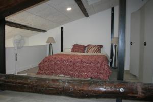 a bedroom with a bed with a red comforter at Loft Appartement Vacances in Pinet