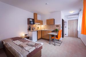 a bedroom with a bed and a small kitchen at Penzion Rita in Lišov