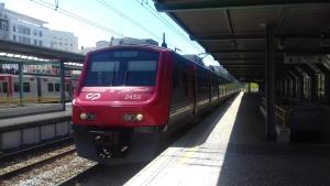 a red train is pulling into a train station at Charming Guesthouse - Sónias Houses in Lisbon