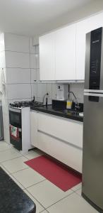La cuisine est équipée de placards blancs et d'un four avec plaques de cuisson. dans l'établissement FORTALEZA APTo INTEIRO 5 HOSPEDES, à Fortaleza