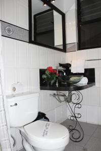 a bathroom with a toilet and a sink and a mirror at Tika Wasi Casa Boutique in Cusco