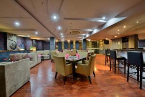a restaurant with tables and chairs and a bar at Grand Serela Setiabudhi Bandung in Bandung