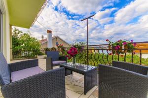 a patio with wicker chairs and a table with flowers at House Marija in Trogir