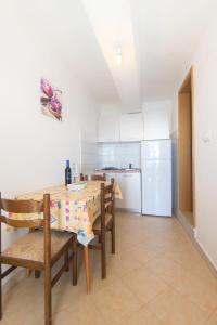 a kitchen with a table and chairs and a refrigerator at Apartments Robinzon Petar in Gdinj +34 photos