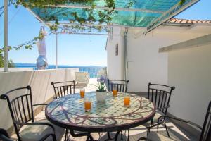 a table on a patio with a view of the ocean at Apartments Robinzon Petar in Gdinj