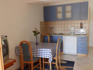 eine Küche mit einem Tisch und Stühlen sowie eine Küche mit blauen Schränken in der Unterkunft Apartment Ren - 150m from beach in Kampor