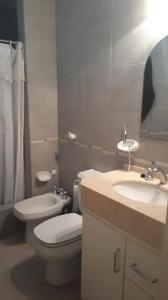a white bathroom with a toilet and a sink at Habitaciones confortables con baño privado in San Rafael