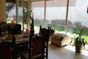 uma sala de jantar com uma mesa e uma grande janela em Habitaciones confortables con baño privado em San Rafael