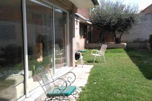 a cat is standing on a patio outside of a house at Habitaciones confortables con baño privado in San Rafael