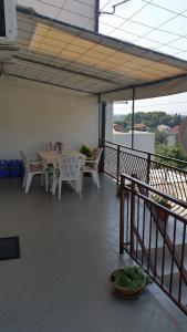 eine Terrasse mit einem Tisch und Stühlen auf dem Balkon in der Unterkunft Apartment Per - sea view & parking space in Banjol