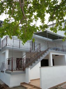 ein weißes Gebäude mit einer Seitentreppe in der Unterkunft Apartment Per - sea view & parking space in Banjol