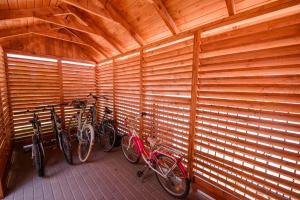 eine Gruppe von Fahrrädern, die in einem Raum mit Holzwänden geparkt werden in der Unterkunft Willa Vacanza in Łeba
