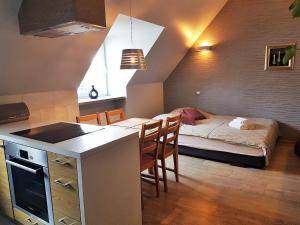 a room with a kitchen and a bedroom with a bed at Apartament Anny in Sopot