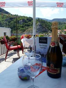 a bottle of wine and a glass on a table at Apartment Lotika in Višegrad