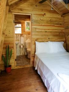 ein Schlafzimmer mit einem Bett in einem Blockhaus in der Unterkunft Bodhi Santa Catalina in Santa Catalina