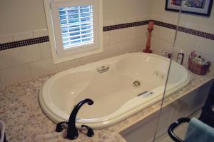 a bath tub in a bathroom with a window at The Lace Curtain Cottage in Chadwicks